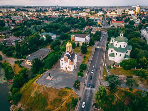 Preview: Aerial view of two old churches near river and bridge in small european city