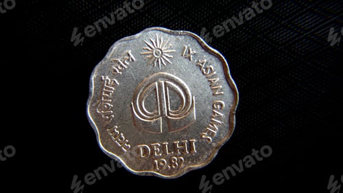 Preview: Overhead closeup shot of a coin representing Indian currency on the dark background