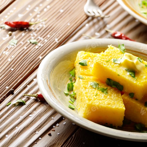 Preview: Polenta with butter and greens on clay dish on wooden rustic tab