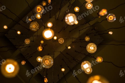Preview: Up-shot of many lights with dim light hanging from the ceiling on wires
