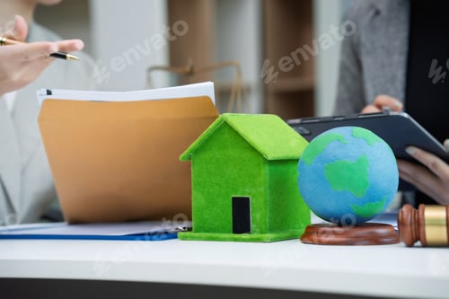 Preview: Two businesswomen review real estate documents using a greenhouse model, a globe, court hammer
