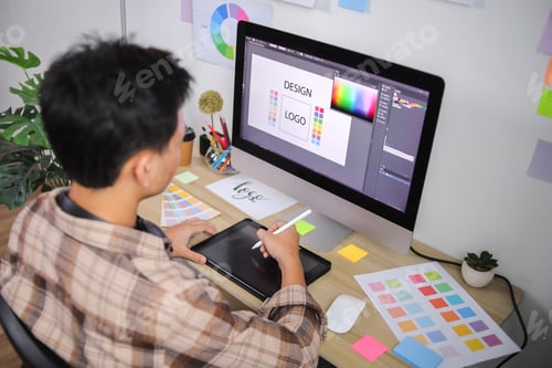 Preview: Creative Professional Using Graphics Tablet and Stylus to Refine Logo Design