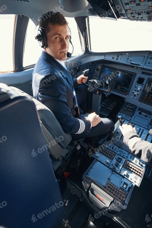 Preview: Plane captain turning to camera from his seat in cockpit