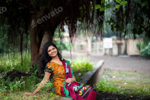 Preview: Happy Indian woman near banyan tree