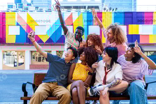 Preview: Multiethnic group of young friends meeting and having fun outdoors