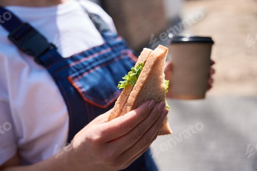 Preview: Building engineer has lunch break, eating sandwich and drinking coffee