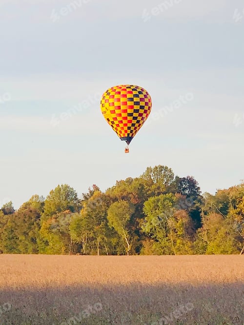 Preview: Hot air balloon flying over the field.