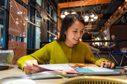 Preview: Woman look at the menu in restaurant