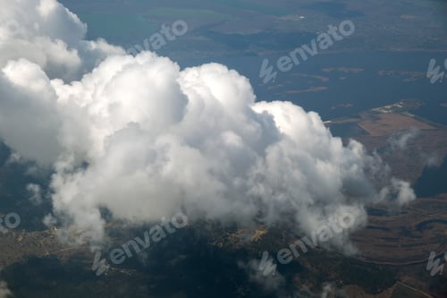 Preview: Aerial view from airplane window of white puffy clouds on bright sunny day