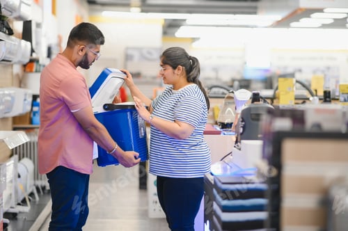 Preview: A indian young couple chooses a plastic cool box for outdoor recreation in an electronics store
