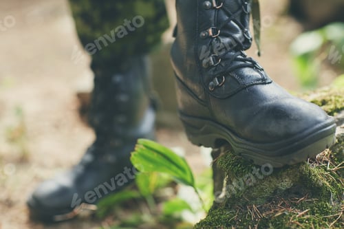 Preview: close up of soldier feet with army boots in forest