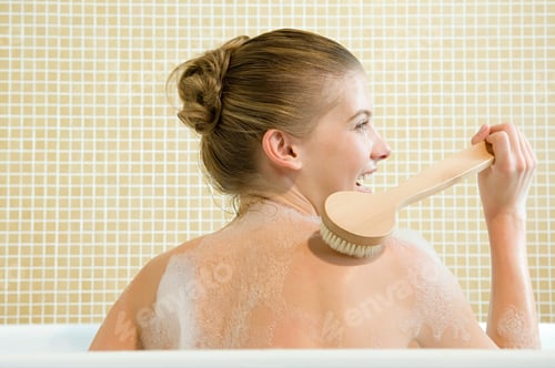 Preview: A young woman with a refreshing smile using a bath brush
