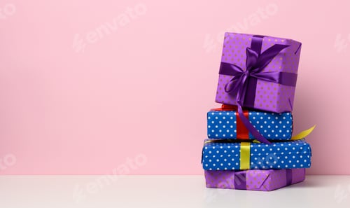 Preview: Boxes packed in festive blue paper and tied with silk ribbon on white background