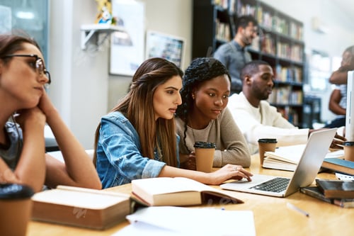 Preview: Shot of two young women using a laptop together in a college library