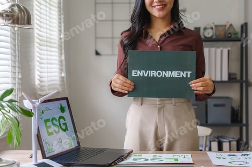Preview: Businesswoman showing environment sign promoting esg policies
