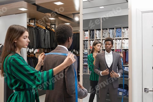 Preview: Client in shop in elegant suit looking at mirror