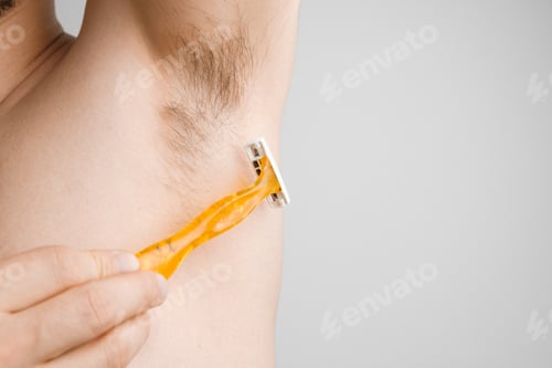 Preview: Close up man shaves hairy armpits with a yellow razor. Unshaved armpits or underarm. Depilation and