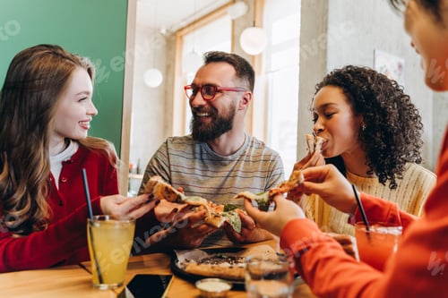 Preview: Friends eating pizza together in restaurant and having fun