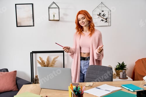 Preview: Cozy winter moments: a young woman with red hair enjoying her home workspace