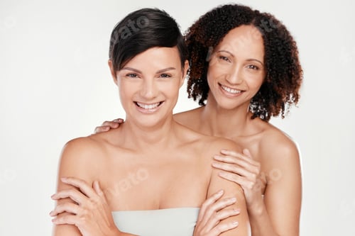 Preview: Cropped portrait of two beautiful mature women posing against a grey background in studio