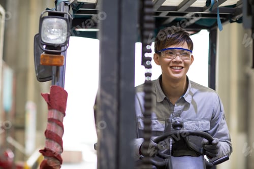 Preview: Young workman driving forklift in the factory