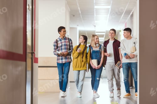 Preview: group of smiling high school classmates walking by school corridor together