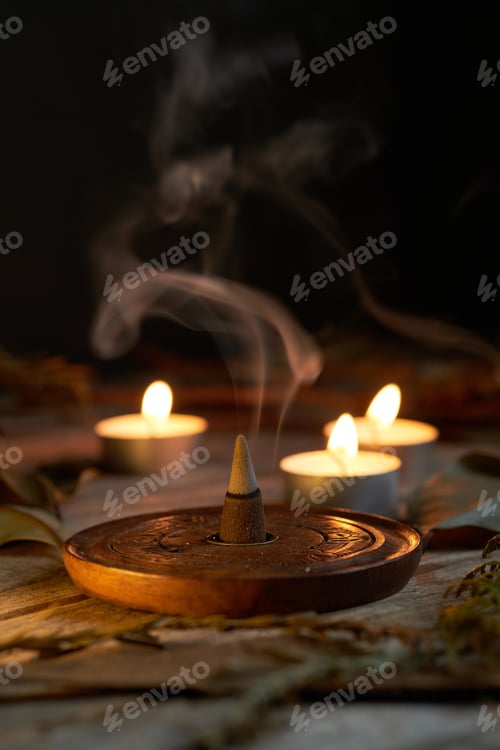 Preview: Incense burning in dim light with candles creating a tranquil atmosphere