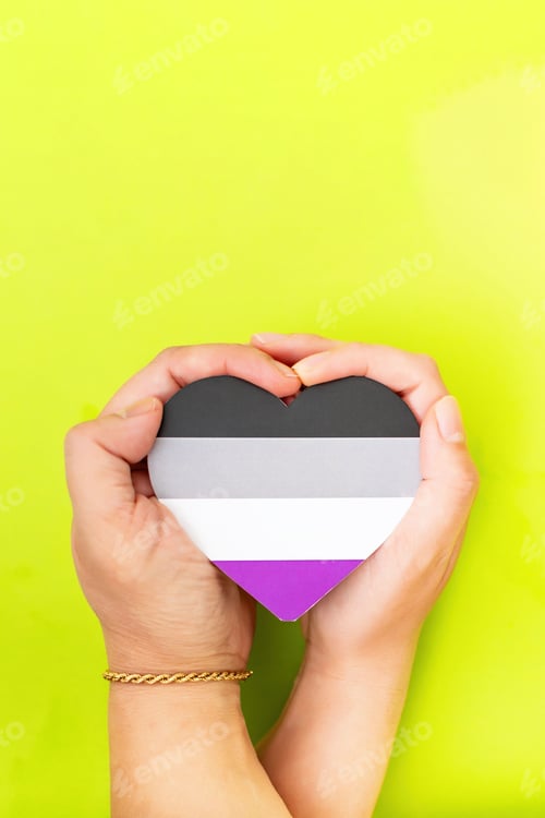 Preview: Hands holding a heart in the colors of the asexual flag on a yellow background with copy space