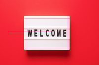 Preview: Lightbox with word welcome on red background, top view. Space for text