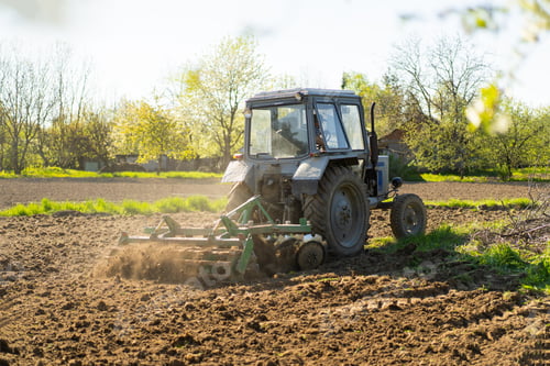 Preview: The tractor drives across the field and cultivates the land.