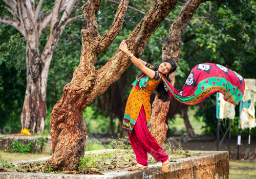 Preview: Young girl near tree trunk and she enjoying fresh air outdoors