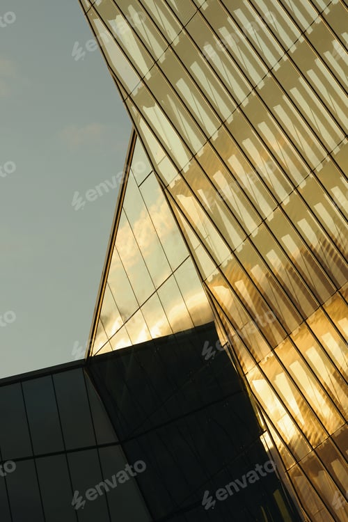 Preview: Modern Glass Skyscraper Reflecting Sunlight during Golden Hour in Cityscape