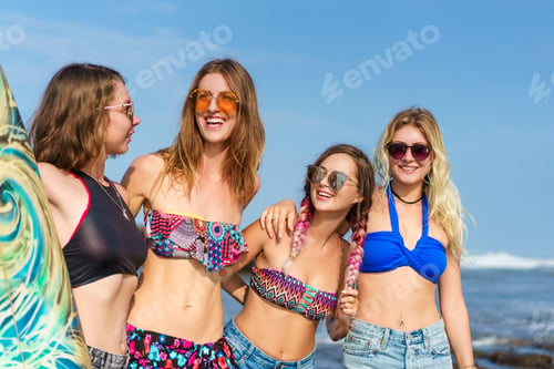 Preview: group of young women in bikini with surfboard posing on beach