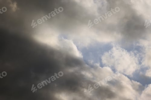 Preview: Dark Clouds In Sky With Sun Ray - Photograph Of Some Late Afternoon Gray And White Clouds In A Blue