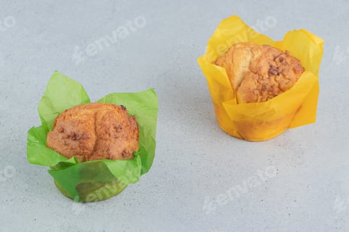 Preview: Delicious Muffins in Colorful Wrappers on Gray Surface