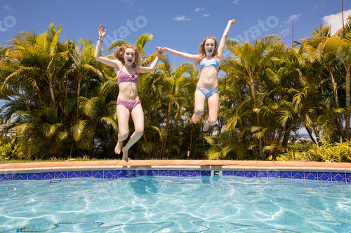 Preview: Two teenage girls jumping in a swimming pool