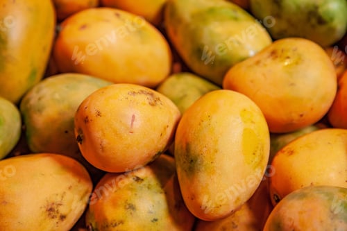 Preview: selective focus of pile of yellow mangoes