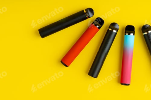 Preview: Colorful disposable electronic cigarettes on yellow background