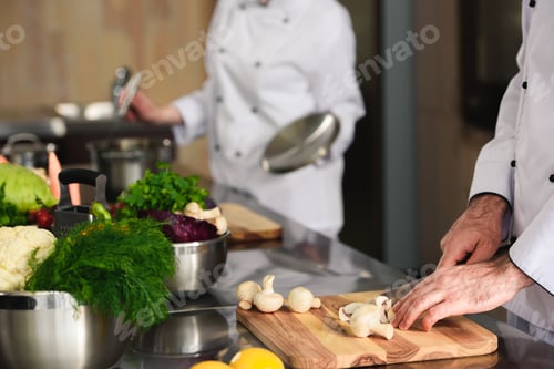 Preview: Close-up view of professional team of cooks preparing ingredients on kitchen