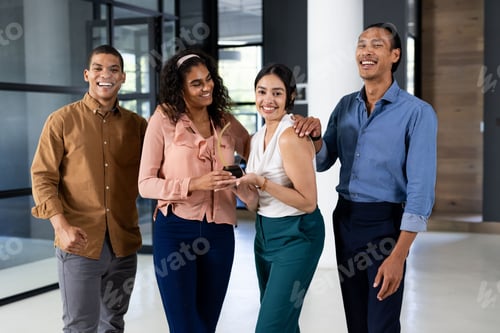 Предпросмотр: Разнообразная бизнес-команда в офисе смеется и держит смартфон в руках