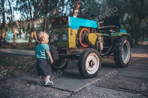 Preview: kid studying tractor on the farm