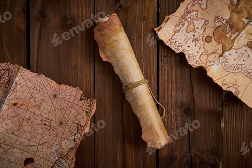 Preview: Antique parchment scroll with old maps on a wooden table.