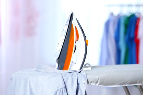 Vista previa: Modern electric iron and clean shirt on board indoors