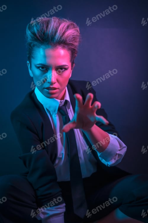Preview: A sexy young blonde hair female in a black suit posing in studio