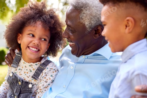 Preview: Loving Grandfather Talking With Grandchildren In Garden At Home