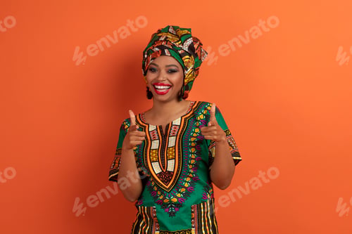 Preview: Funny positive black woman pointing at camera on orange