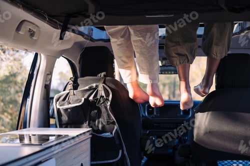 Preview: feet dangling off the elevated bed of a camper van