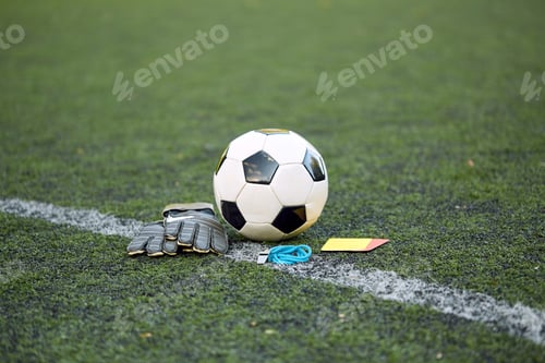 Preview: ball, gloves, whistle and cards on soccer field