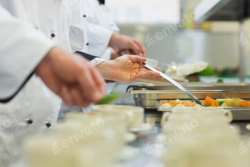 Preview: Chefs Standing In A Row Preparing Food In A Modern Kitchen