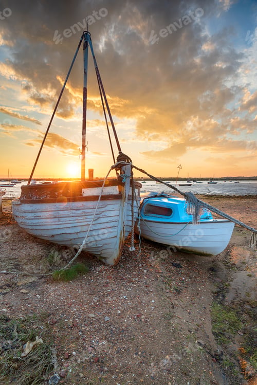 Preview: Stunning sunset over old fishing boats on the shore at West Mers